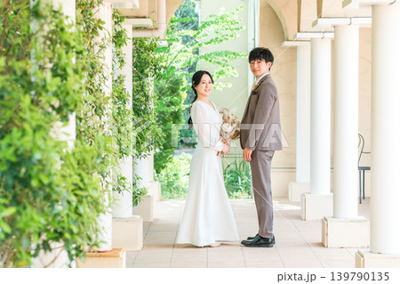 ブーケを持って向かい合う新郎新婦(ウェディング・ブライダル・夫婦) 139790135