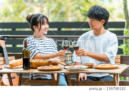 ウッドデッキ,テラス席,バルコニー席で食事するカップル,夫婦（グランピング・ベランピング） 139790182
