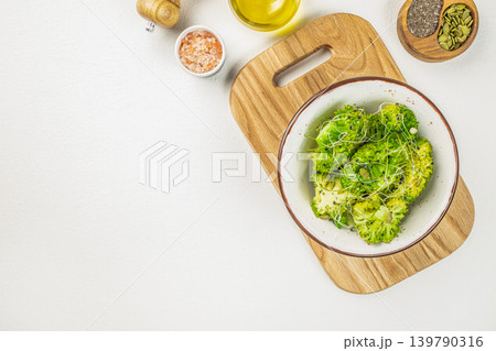 Broccoli salad bowl with microgreens and seeds on white background top view 139790316