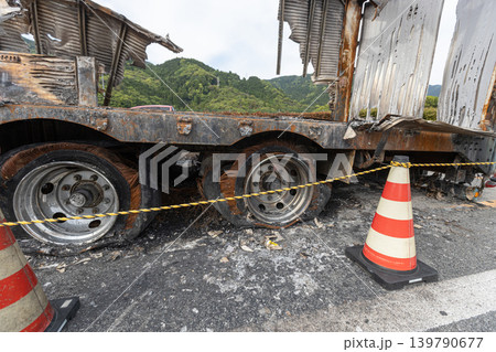 車両火災でボロボロになっているトラックの素材 タイヤも破裂して中の繊維がむき出しになっている 車両火災でボロボロになっているトラックの素材 タイヤも破裂して中の繊維がむき出しになっている 139790677