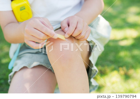 膝に絆創膏を貼る小学生 139790794