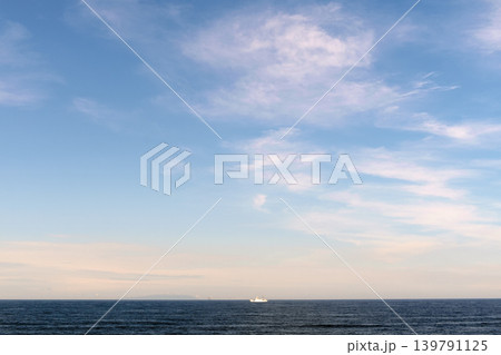 穏やかな海に浮かぶ小さな船と淡い雲の空 139791125