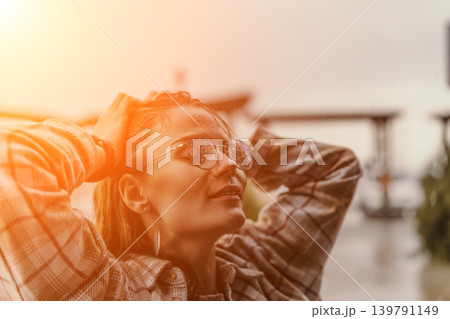 Woman rain glasses young female enjoying raindrops on her spectacles during sunset with hands on head and copy space 139791149