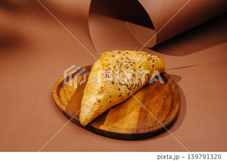 Freshly baked pastry on a wooden plate with brown background 139791320
