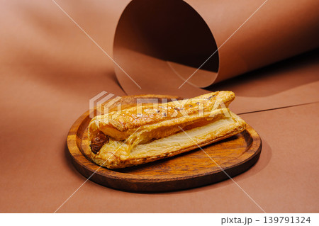 Freshly baked pastry placed on a wooden plate with a brown background 139791324