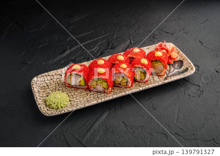 Sushi rolls on a decorative plate with wasabi and pickled ginger on the side 139791327