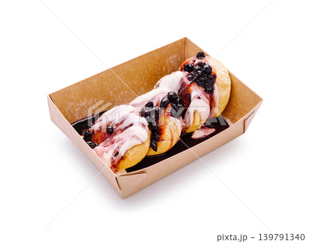 Dessert cottage cheese pancakes with berry sauce in a cardboard box at a food market Dessert cottage cheese pancakes with berry sauce in a cardboard box at a food market 139791340