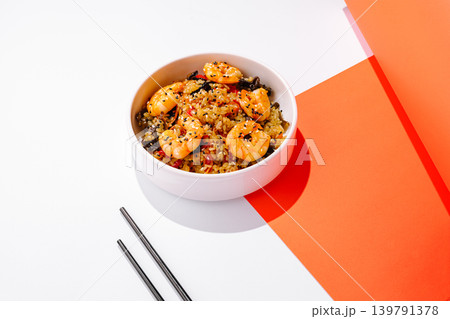 Shrimp fried rice served in a bowl on a white table with colorful background Shrimp fried rice served in a bowl on a white table with colorful background 139791378
