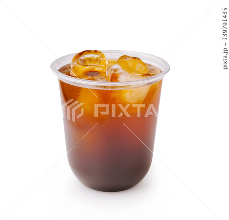 Iced coffee served in a clear plastic cup with ice cubes on a bright background 139791435