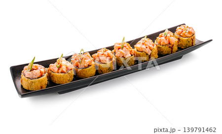 Sushi rolls served on a black plate with colorful toppings at a restaurant 139791462