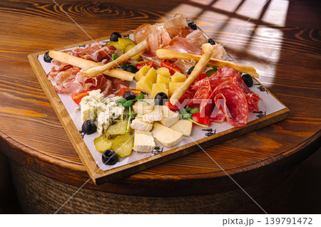 Savory platter of meats, cheeses, and snacks on a wooden table 139791472