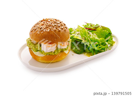Shrimp sandwich with salad served on a white plate in a well-lit kitchen 139791505