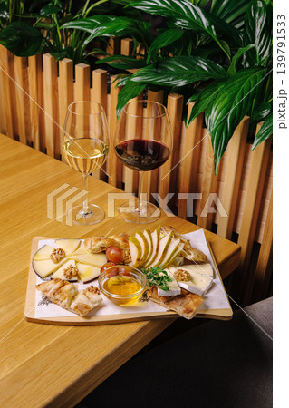Cheese and wine pairing with fruit at a table in a dining setting 139791533