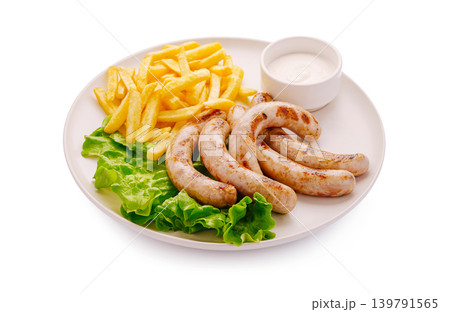 Grilled sausages on a plate with fries and dipping sauce at a meal time Grilled sausages on a plate with fries and dipping sauce at a meal time 139791565