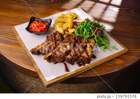 Enjoying tasty ribs with sides at a restaurant during lunch hour Enjoying tasty ribs with sides at a restaurant during lunch hour 139791578