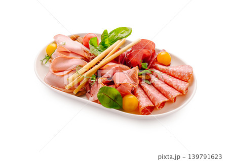 Lunch platter with cold cuts, greens, and snacks on a white background Lunch platter with cold cuts, greens, and snacks on a white background 139791623
