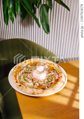 Fresh pizza with toppings on a wooden table in a cozy restaurant setting 139791679