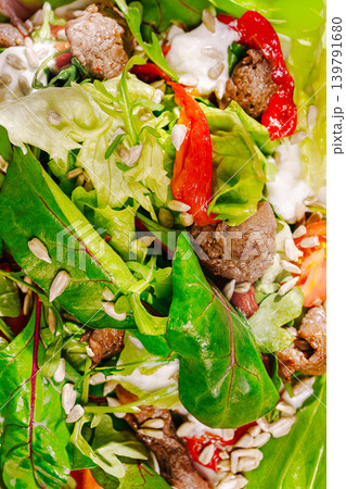 Fresh salad with greens, meat, and seeds on a sunny day at the park 139791680