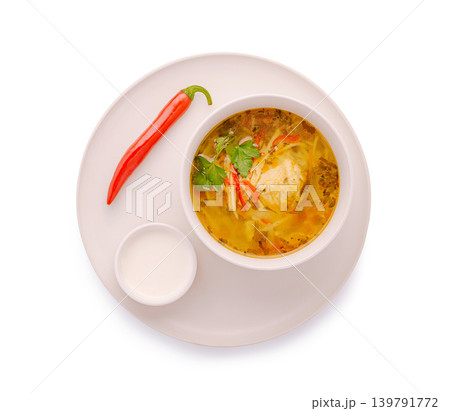 Warm soup served with chili and sauce on a white plate during meal time Warm soup served with chili and sauce on a white plate during meal time 139791772