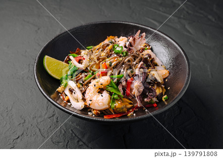 Mixed seafood dish with noodles, lime, and herbs in a black bowl Mixed seafood dish with noodles, lime, and herbs in a black bowl 139791808