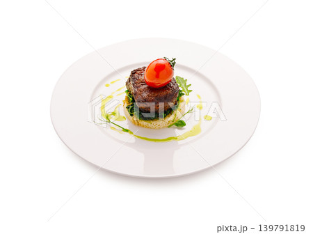 Steak with tomato served on a white plate with green garnish and sauce Steak with tomato served on a white plate with green garnish and sauce 139791819