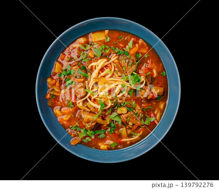 Dish with noodles and meat in a blue bowl on a black background Dish with noodles and meat in a blue bowl on a black background 139792276