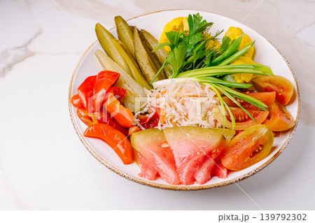 Assorted pickled vegetables platter on white marble background 139792302