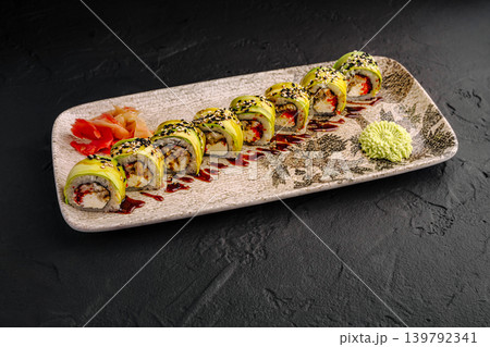 Green dragon sushi rolls with avocado and eel served with wasabi and ginger on a decorative plate 139792341