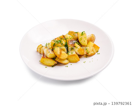 Roasted potatoes served on a white plate with green herbs for garnish Roasted potatoes served on a white plate with green herbs for garnish 139792361