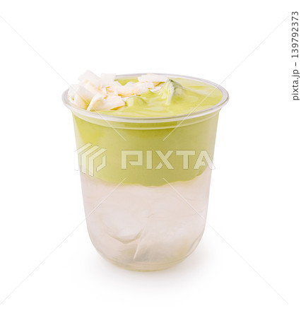 Layered matcha coconut drink with ice in a clear cup Layered matcha coconut drink with ice in a clear cup 139792373