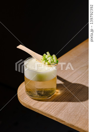 Cold drink with cucumber garnish served on wooden table Cold drink with cucumber garnish served on wooden table 139792392