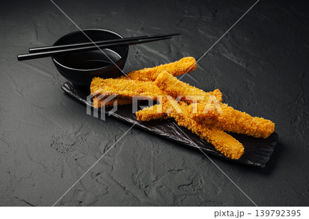 Crispy fried snacks served with dipping sauce and chopsticks on black plate Crispy fried snacks served with dipping sauce and chopsticks on black plate 139792395