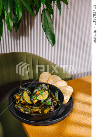 Delicious mussels with lime and bread served on a wooden table Delicious mussels with lime and bread served on a wooden table 139792415