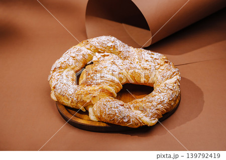 Delicious pastry on a wooden plate with a simple brown background 139792419