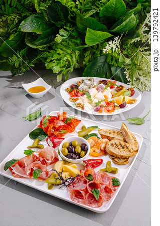 Cheese and meat platter served with greens on a dining table Cheese and meat platter served with greens on a dining table 139792421