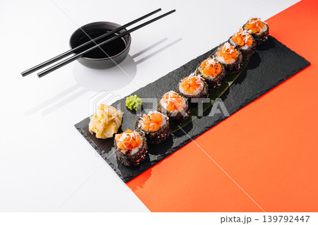 Crispy tempura sushi rolls with salmon tartare topping served on a dark slate plate with ginger and wasabi Crispy tempura sushi rolls with salmon tartare topping served on a dark slate plate with ginger and wasabi 139792447