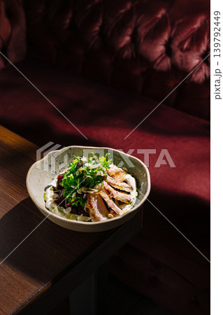 Delicious meal served in a bowl on a wooden table in a cozy setting Delicious meal served in a bowl on a wooden table in a cozy setting 139792449