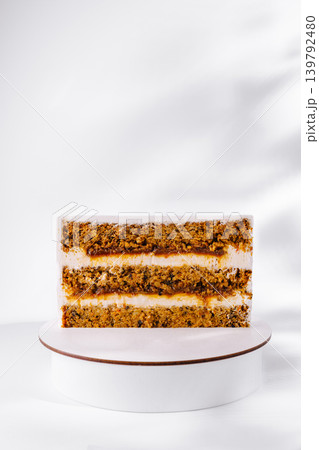 Carrot cake with cream cheese frosting on white display stand Carrot cake with cream cheese frosting on white display stand 139792480