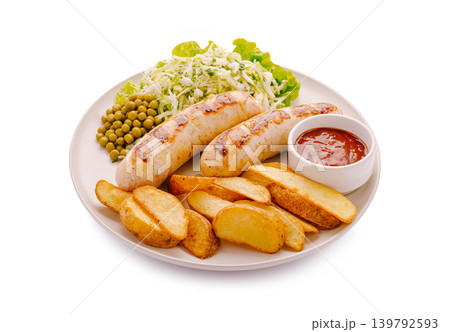 Grilled sausages with potatoes, peas, and salad on a plate during lunch Grilled sausages with potatoes, peas, and salad on a plate during lunch 139792593