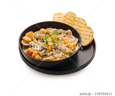 Seafood pasta dish with grilled bread on a black plate Seafood pasta dish with grilled bread on a black plate 139792621