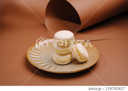 Delicious macarons stacked on a plate with brown background 139792627