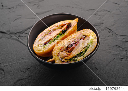 Chicken sandwich halves in black bowl on stone 139792644