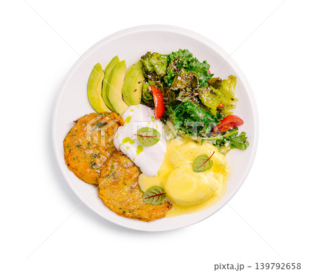 Potato pancakes with poached egg avocado and salad and sauces at a dining table 139792658