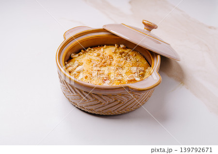 Delicious dessert prepared in a clay pot on a kitchen counter Delicious dessert prepared in a clay pot on a kitchen counter 139792671