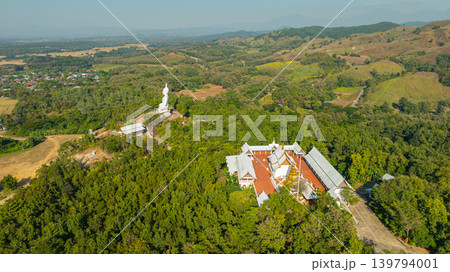 Aerial view of whit big Buddha on the hill of Wat Phra That Pu Jae Aerial view of whit big Buddha on the hill of Wat Phra That Pu Jae 139794001