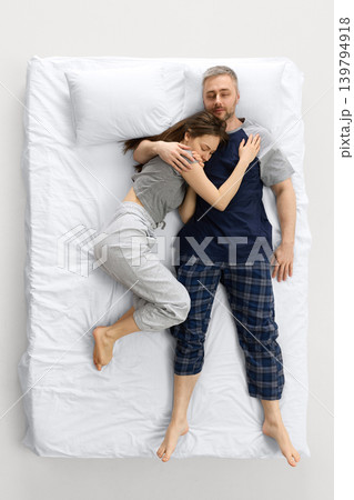 Couple sleeping together on white bed in top view cozy home scene. Couple sleeping together on white bed in top view cozy home scene. 139794918