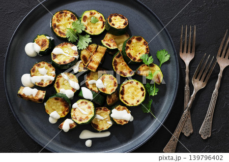 fried zucchini with garlic yogurt sauce on plate fried zucchini with garlic yogurt sauce on plate 139796402
