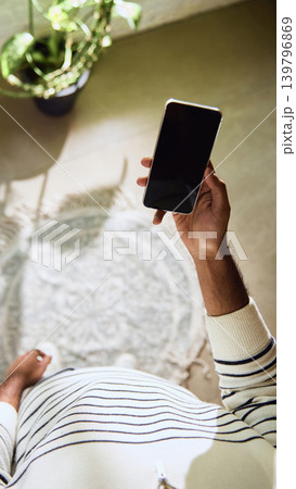 Man holding smartphone with blank screen in bright home interior from first person view. 139796869