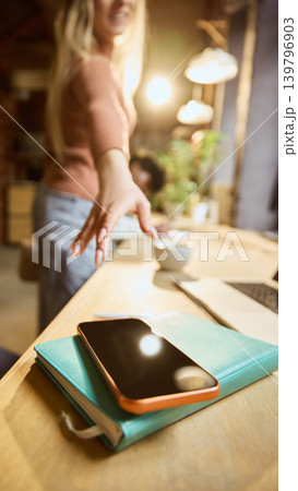 Close up of woman reaching for phone at workspace. Close up of woman reaching for phone at workspace. 139796903