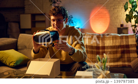 Man unboxing virtual reality headset at home new tech gadget online purchase Man unboxing virtual reality headset at home new tech gadget online purchase 139797385